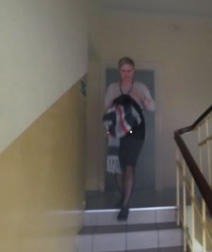 schodząca kobieta po schodach zadymionej klatki schodowej