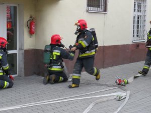 strażacy przed wejściem do budynku komendy