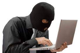 Zamaskowany mężczyzna trzyma laptop na ręce