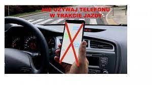 kierowca trzyma w ręku telefon podczas jazdy