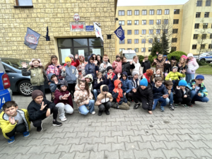 pamiątkowe zdjęcie dzieci przed wejściem do budynku Komendy Miejskiej Policji w Radomiu