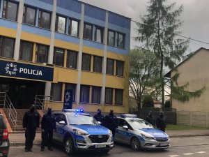 Funkcjonariusze z KPP w Kozienicach przed budynkiem KPP w Kozienicach przy radiowozach oznakowanych oddają hołd zmarłemu na służbie koledze