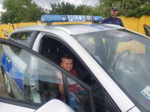 policjanci z dziećmi podczas plenerowej akcji profilaktycznej