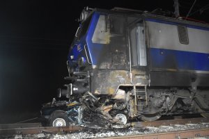 Fotografia kolorowa: zderzenie pociągu osobowego z samochodem marki BMW w Mławie, ul. Płocka w rejonie trakcji kolejowej.
