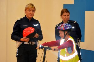dwie policjantki oraz dziecko w kasku ochronnym