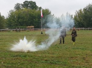 Dowódca Pułtuskiej Grupy Rekonstrukcji Historycznej 13. Pułku Piechoty  z chłopcem podczas pokazu przedstawiającego nieumiejętne korzystanie z petard