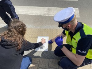 Policjanci i uczeń tworzący symbol przekreślonego telefonu komórkowego