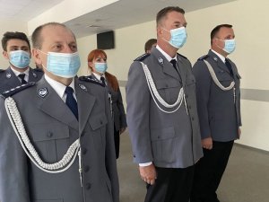 Policjanci w umundurowaniu galowym stoją w maskach