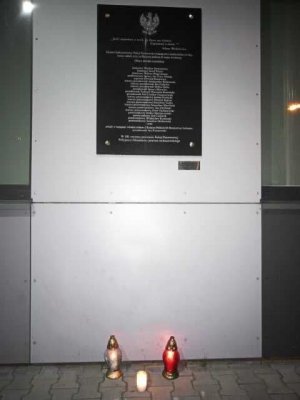 Znicze przed tablicą pamiątkową na ścianie budynku sochaczewskiej jednostki policji