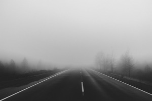 Zdjęcie przedstawia jezdnię. W powietrzu unosi się mgła