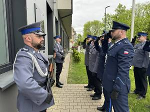 Policjanci oddają honor przed tablicą pamięci