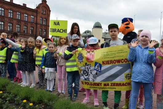 Dzieci trzymające plakaty z hasłem działań &quot;Kierowco! Nie polujemy na zebrach&quot;.
