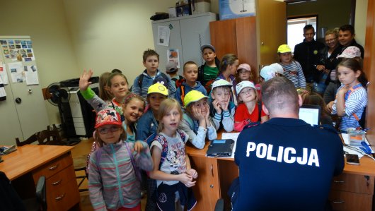 Dzieci uważnie słuchały czym zajmuje się policjant pracujący w zespole ds. wykroczeń