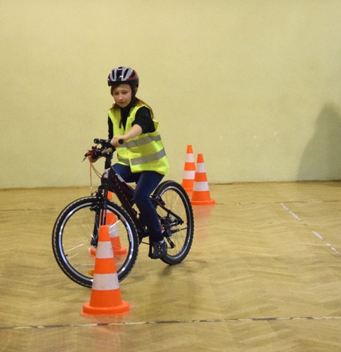 Dziewczynka jadąca na rowerze przez or rowerowy.
