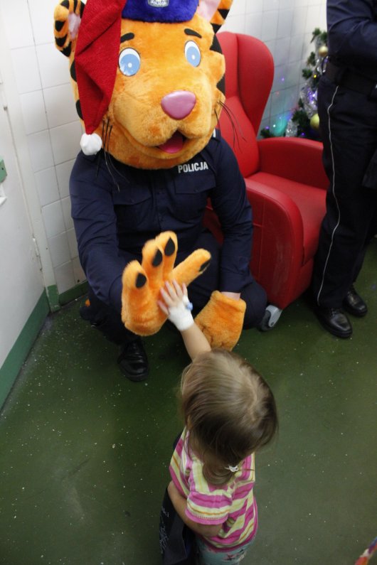 Policyjna maskotka-tygrys przybija piątkę dziewczynce