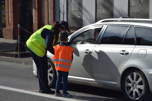 Policjant podchodzi wraz z dzieckiem do samochodu